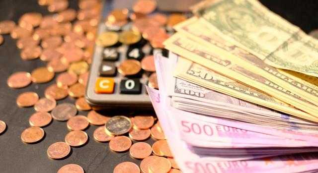 Ayuda asociada al aval de un préstamo concedido por el ICO Caso practico sobre la contabilización de una ayuda asociada al aval de un préstamo concedido por el ICO. Imagen de monedas, billetes y una calculadora