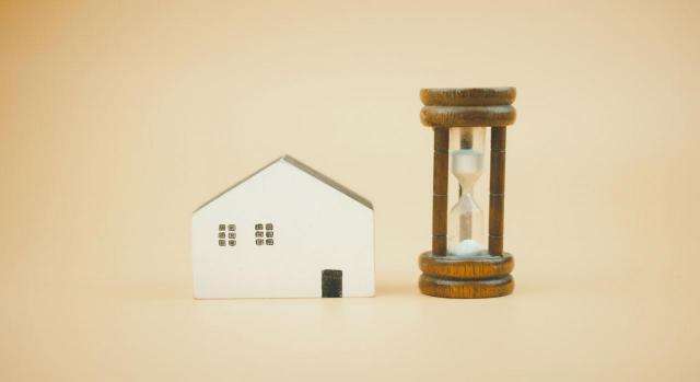 Aplicación práctica de la consulta 6 del BOICAC 113 sobre la adquisición de un activo por usucapión Tratamiento contable de la adquisición de un activo por usucapión. Imagen de una casa con un reloj de arena a su lado
